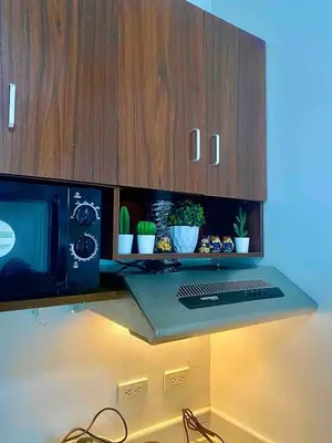 a kitchen counter with a microwave and some potted plants at Luxurious Homey Suite IN FRONT of US Embassy Manila Bay in Manila