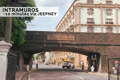 a bridge over a street with a car driving under it at Luxurious Homey Suite IN FRONT of US Embassy Manila Bay in Manila
