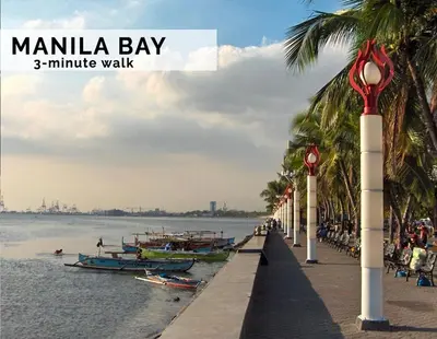 a beach with palm trees and boats in the water at Luxurious Homey Suite IN FRONT of US Embassy Manila Bay in Manila