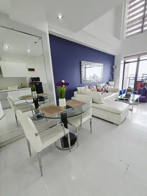 a living room with a couch and a table and chairs at 1 BR Loft type in Manila