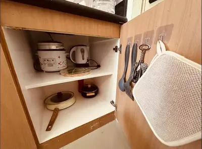 a cupboard filled with appliances and utensils at Jazz Residences Condominium in Manila