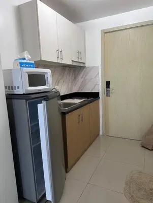 a kitchen with a microwave on top of a refrigerator at Jazz Residences Condominium in Manila