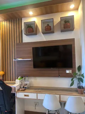 a living room with a flat screen tv on a wall at Jazz Residences Condominium in Manila