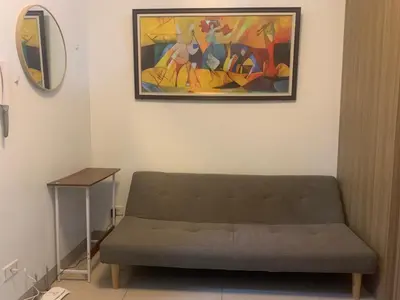 a couch in a room with a painting on the wall at Shore Residences by Buhay Staycation in Manila
