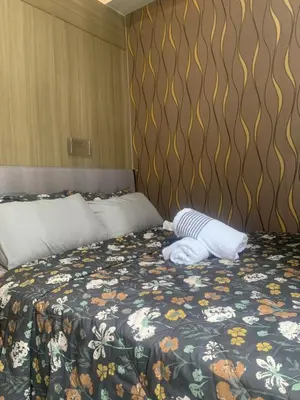a bedroom with a bed with a floral bedspread at Shore Residences by Buhay Staycation in Manila