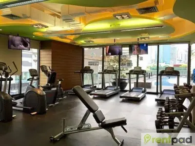 a gym with several treadmills and elliptical machines at STUDIO Type CONDO in Manila