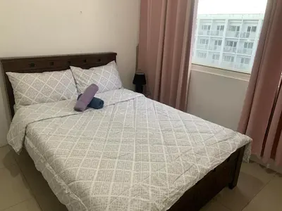 a bed with a purple stuffed animal sitting on it at Shore Residence by Buhay Staycation in Manila