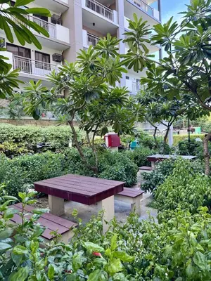 a picnic table in a garden in front of a building at Alea Residences 1 Bedroom Condo with Pool View Balcony in Manila