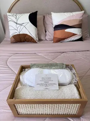 a wooden tray with a basket on a bed at Alea Residences 1 Bedroom Condo with Pool View Balcony in Manila