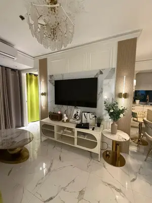 a living room with a large television on a wall at Azure 2BR Beach View Suite- Bathtub, Smart Toilet, Netflix in Manila