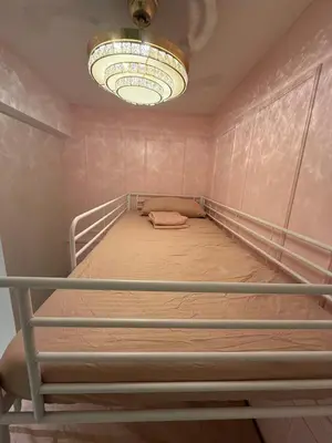 an empty bed in a room with a chandelier at Azure 2BR Beach View Suite- Bathtub, Smart Toilet, Netflix in Manila