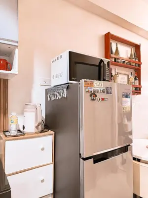a microwave sitting on top of a refrigerator in a kitchen at FOG Staycation in Manila