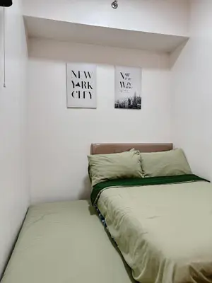 a bed in a room with two posters on the wall at FOG Staycation in Manila