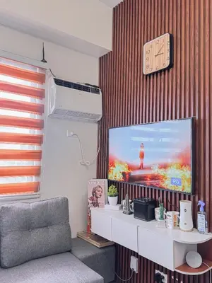 a living room with a flat screen tv on a wall at FOG Staycation in Manila