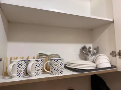 a shelf with cups and plates on it at Manila Flat Mall of Asia SMX city view with netflix in Manila