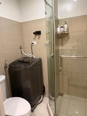 a bathroom with a toilet and a glass shower at Manila Flat Mall of Asia SMX city view with netflix in Manila