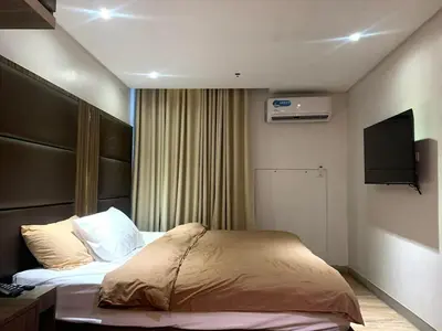 a hotel room with a bed and a flat screen tv at Studio in serenity - Peaceful and Calm ambiance in Manila