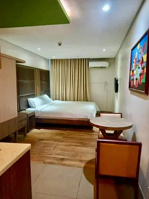 a hotel room with a bed and a table at Studio in serenity - Peaceful and Calm ambiance in Manila
