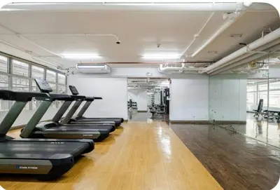 a row of treadmills in a gym with wooden floors at Studio in serenity - Peaceful and Calm ambiance in Manila