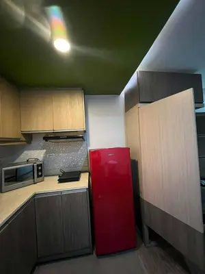 a kitchen with a red refrigerator in a room at Studio in serenity - Peaceful and Calm ambiance in Manila