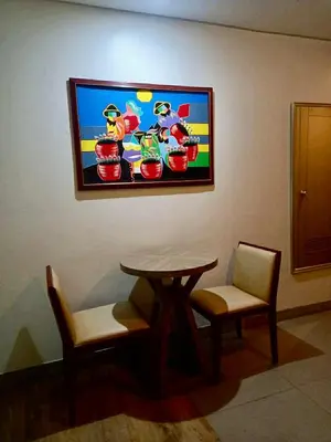 a tv hanging on a wall with a table and chairs at Studio in serenity - Peaceful and Calm ambiance in Manila
