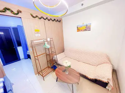 a small bedroom with a bed and a table at SHORE 1 MALL OF ASIA Staycation in Manila