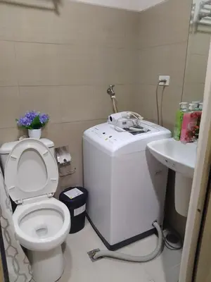 a bathroom with a toilet and a sink at SHORE 1 MALL OF ASIA Staycation in Manila