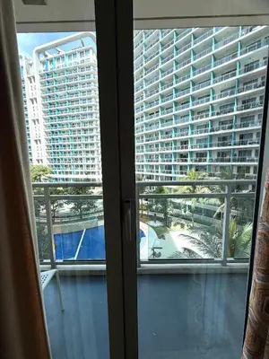 a view of a large building from a window at SYM staycation at Azure in Manila