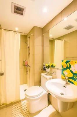 a bathroom with a toilet and a sink at SYM staycation at Azure in Manila