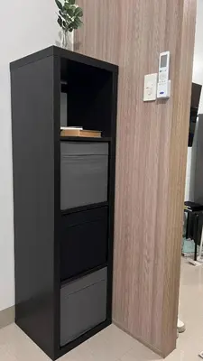 a black book shelf next to a wooden wall at Modern apartment with balcony and Pool View in Manila