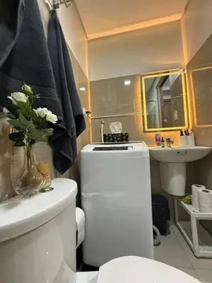 a bathroom with a white toilet and a sink at Modern apartment with balcony and Pool View in Manila