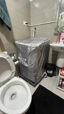a bathroom with a toilet with a plastic cover on it at Modern apartment with balcony and Pool View in Manila