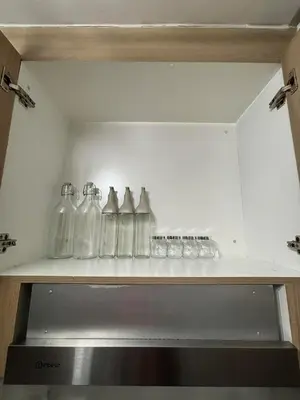 a row of glass bottles on a shelf at Modern apartment with balcony and Pool View in Manila