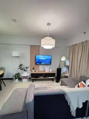 a living room with a couch and a flat screen tv at Alea Residences 2 Bedroom Condo with Pool View Balcony in Manila