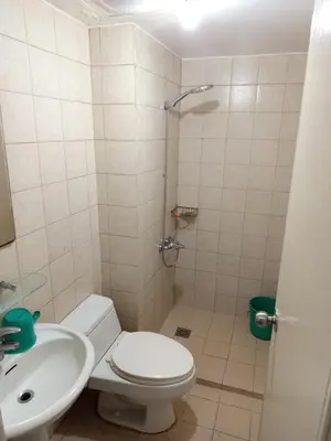 a bathroom with a shower and a toilet and a sink at Grand Soho Makati in Manila