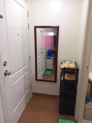 a hallway with a mirror and a white door at Grand Soho Makati in Manila
