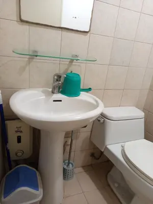 a bathroom with a sink and a toilet at Grand Soho Makati in Manila
