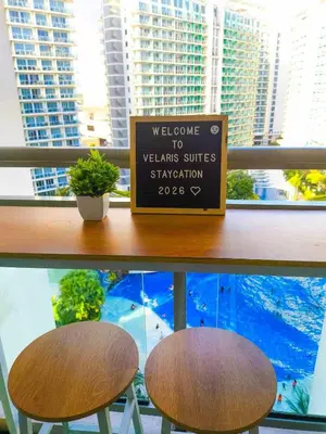 a sign sitting on top of a table with two stools at Azure Staycation in Manila