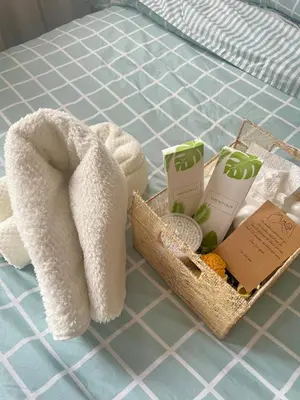 a towel and a basket with towels and other products on a bed at Shore 2 Residences, Tower 1 in Manila