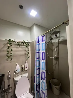 a bathroom with a toilet and a shower with a shower curtain at Shore 2 Residences, Tower 1 in Manila
