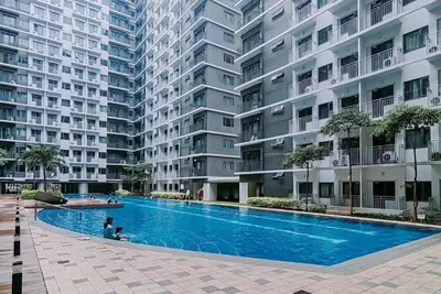 a swimming pool in front of a large apartment building at 1BR Near MOA Balcony & Wi-Fi in Manila