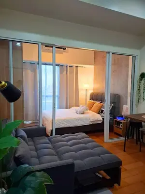 a bedroom with a bed and a couch in a room at 1BR with balcony near Makati in Manila