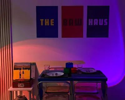 a table with two chairs in a room with purple lights at The Bawhaus in Manila