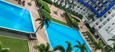 an overhead view of a building with a large swimming pool at Sea Residences Joy in Manila