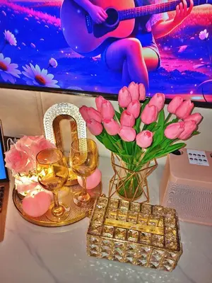 a table with a vase of pink roses and wine glasses at Blush & Glam at SMDC Fame Residences Tower 3 in Manila