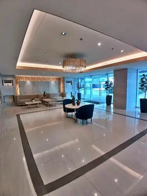 a lobby of a building with a table and chairs at Blush & Glam at SMDC Fame Residences Tower 3 in Manila