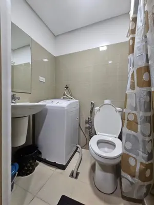 a bathroom with a toilet and a sink at Shore Residences Mall Of Asia Cj in Manila