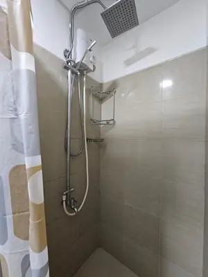a shower with a shower curtain in a bathroom at Shore Residences Mall Of Asia Cj in Manila