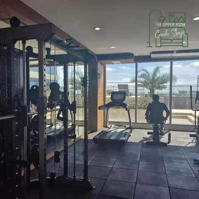 a gym with tread machines and a person riding a bike at 1128 Positano in Manila