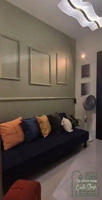 a living room with a blue couch with pillows on it at 1128 Positano in Manila